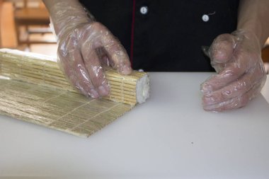 Şef bambu hasırla suşi yapıyor.