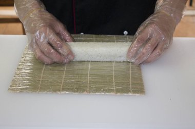 Şef bambu hasırla suşi yapıyor.