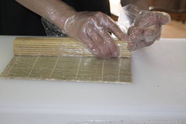 Şef bambu hasırla suşi yapıyor.