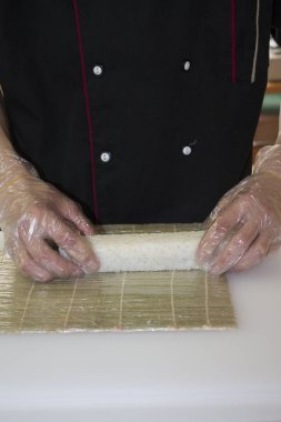 Şef bambu hasırında suşi yapıyor.