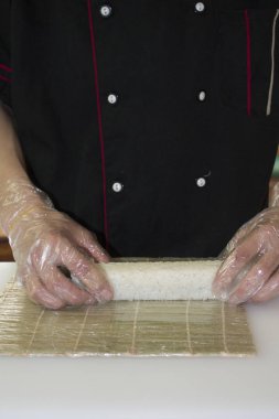 Şef bambu hasırında suşi yapıyor.