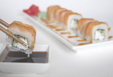 Yemek çubuklarıyla suşi alıp, yakınlaş. 