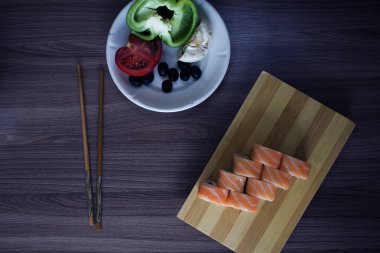 Taze sebzeler ve lezzetli suşiler masada. 