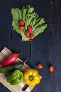 kiraz domates ve kırmızı sarı yeşil biber siyah ahşap tablo