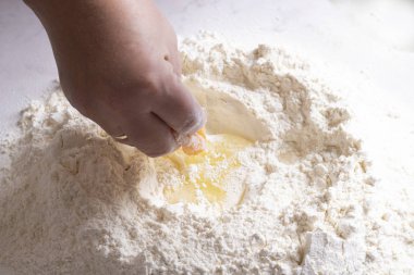 Masada hamur yapan bir kadın resmi.