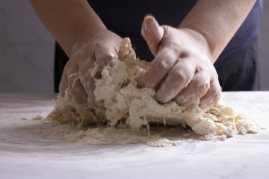 Fırıncı mutfakta ekmek için hamur yoğuruyor.