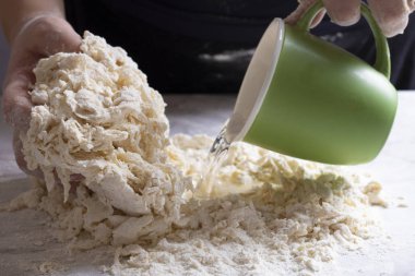 Masada hamur yapan bir kadın resmi.