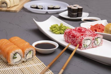 Lezzetli suşi ruloları, sos, masada çubuklar. 