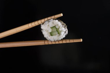 suşi yemek çubukları siyah bir arka plan, metin için yer arasında