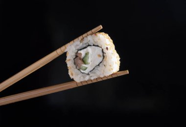 Suşi ve chopsticks siyah bir zemin üzerine