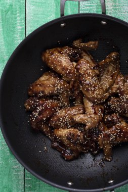 ahşap masa, üstten görünüm üzerinde susam ile kazan içine tavuk kanadı