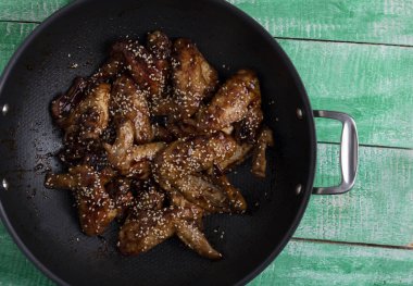 kızarmış tavuk kanatları susam ile kazana, üstten görünüm