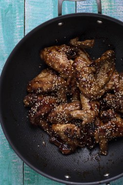 teriyaki sosu ve susam ile kazana, closeup kızarmış tavuk kanatları