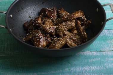 ahşap masa, üstten görünüm üzerinde susam ile kazan içine tatlı tuzlu tavuk kanadı