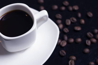  Masada bir fincan espresso ve kahve çekirdeği var.