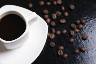  Masada bir fincan espresso ve kahve çekirdeği var.