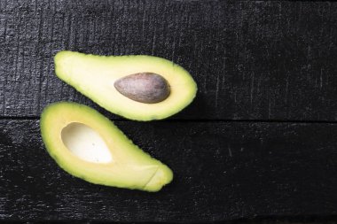 Siyah arka planda izole edilmiş avokado, sağlıklı besin bileşeni.
