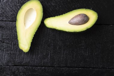 Siyah arka planda izole edilmiş avokado, sağlıklı besin bileşeni.