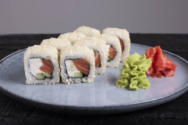 Suşi rulosu, wasabi ve zencefil tabakta.