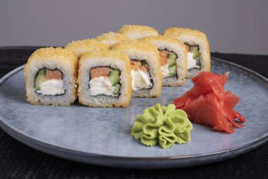 Suşi rulosu, wasabi ve zencefil tabakta.