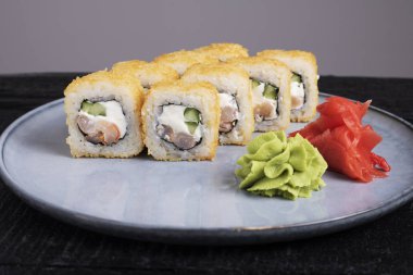 Suşi rulosu, wasabi ve zencefil tabakta.