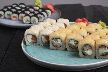 Masadaki mavi tabakta taze suşi ruloları var. 