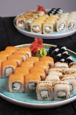 Masadaki mavi tabakta taze suşi ruloları var. 