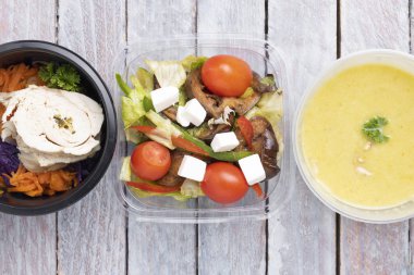 Sebzeli sebze çorbası ve ahşap arka planda bitkiler.