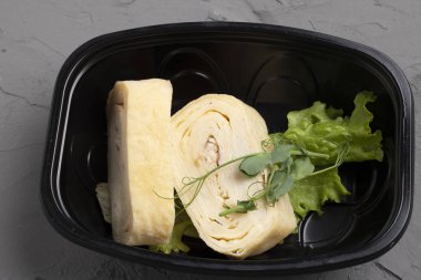 fresh baked cabbage with cheese and parsley on a black plate