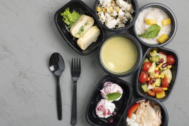 Konteynırlarda, kaşıklarda ve çatallarda leziz yiyeceklerin üst görüntüsü 