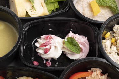 Masadaki konteynırlarda yiyecekleri alın.