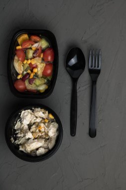 top view of a bowl with vegetables and spices on a black background