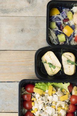 top view of a bowl with vegetables and meat on a wooden background