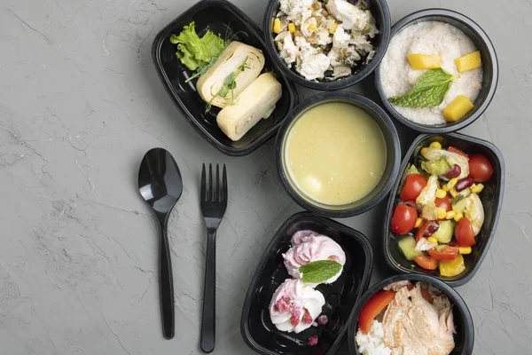 Konteynırlarda, kaşıklarda ve çatallarda leziz yiyeceklerin üst görüntüsü 