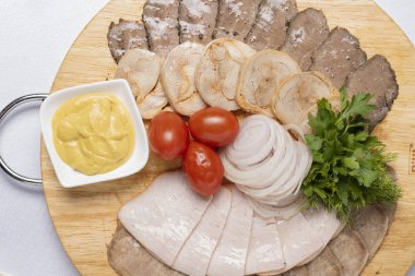 Farklı et türlerinin üst görüntüsü, tahtanın üzerinde hardal.