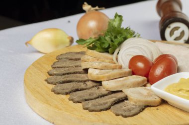 farklı türde et, domates, tahtanın üzerinde hardal.