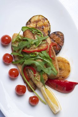 kiraz domates, kızarmış et, mikro yeşillik ve sos, beyaz tabak üzerinde üst görünümü