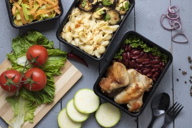 çiğ kabak ve egplants, pişmiş tavuk kanatları ve makarna ile iki gıda kapları