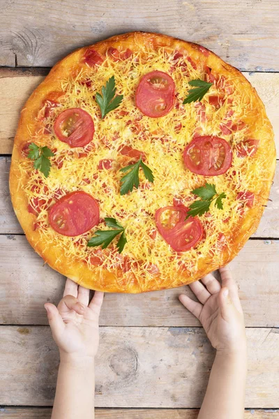 çocukların elleri peynir pizza çalıyor, yukarıdan görünümü