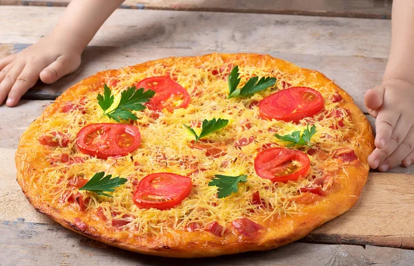 Käsepizza Mit Kräutern Und Tomaten Auf Holzgrund Seitenansicht Und Kinderhänden — Stockfoto