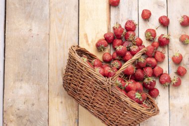 çilek ahşap masa, hasır sepet ve kopya alanı üzerine dağınık