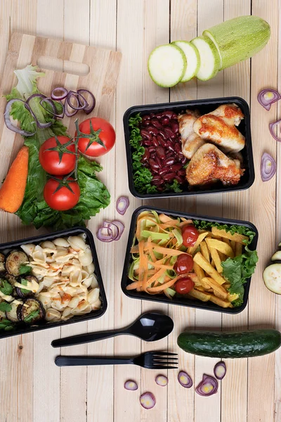 ready meal to eat in plastic food containers, spoon and fork neat vegetables