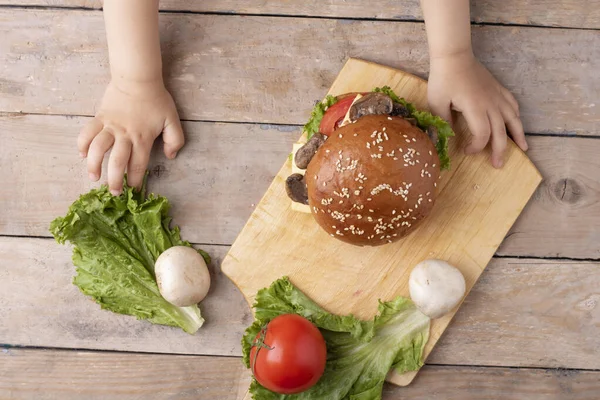 Vista superior do hambúrguer de cogumelos com as mãos das crianças — Fotografia de Stock
