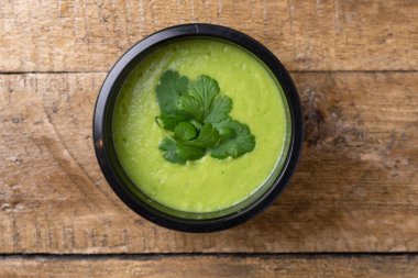 Ahşap minimalizm üzerine yeşil sebze kremalı çorba, metin için yer. Yiyecek teslimatı kavramı