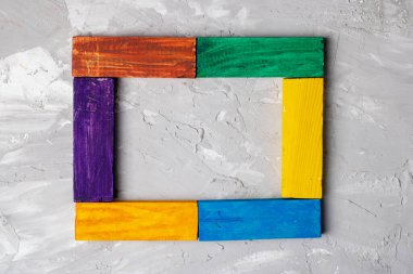 Kare şeklinde tahta bulmacalar, gri arka planda oyuncak küpler. Üst görünüm