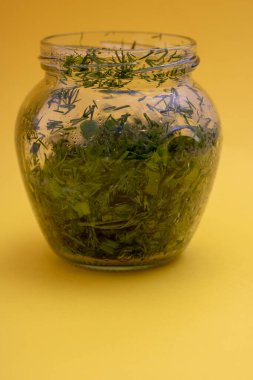 Kasede kurutulmuş otlar, sarı kağıtta baharatlar, dikey.