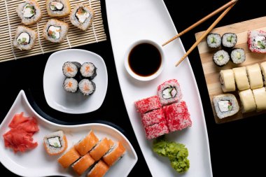 Wasabi, zencefil, sos ve çubuklu renkli suşi. Düz yerde yemek vardı.