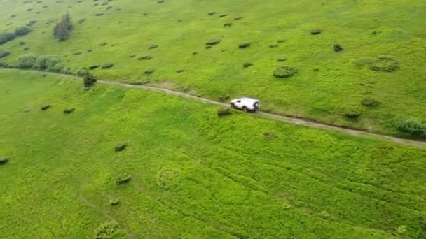 白色越野车在土路上的山地上行驶 空中景观 — 图库视频影像