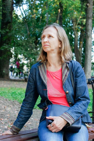 Femme assise sur un banc de parc — Photo