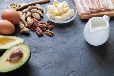 Keto ürün: avokado, tereyağı, pastırma, yumurta, siyah arka plan fındık. Sağlıklı yağlar kavramı